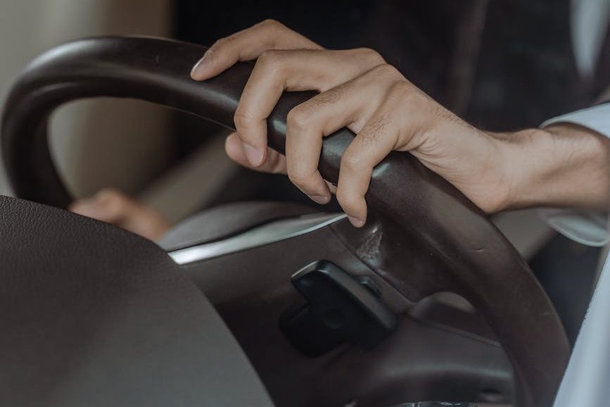 person holding black steering wheel